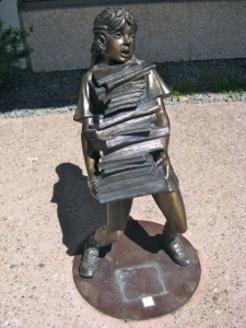 Child carrying stack of books ~ statue at main library in Colorado Springs.  If you got books by Deanna Dwyer, Leigh Nichols, or David Axton, who wrote them? (Dean Koontz)