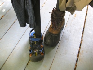Closeup of the chair feet, in Keene walking sandals and hiking boots.